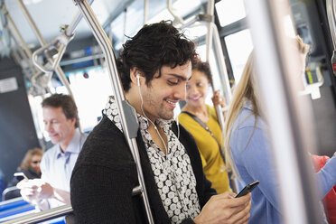 New York City Park. Menschen, Männer und Frauen in einem Stadtbus. Öffentliche Verkehrsmittel. Ein junger Mann, der sein Handy überprüft. - MINF00129