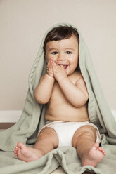 Ein 8 Monate altes Baby mit Stoffwindeln, das auf dem Boden sitzt und eine Bettdecke über dem Kopf hat. - MINF00186