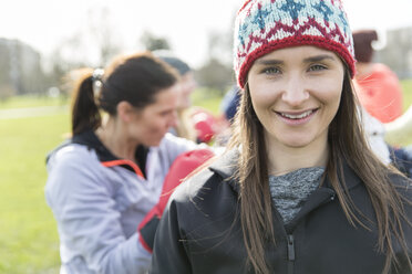 Porträt lächelnde, selbstbewusste Frau beim Sport im Park - CAIF21185