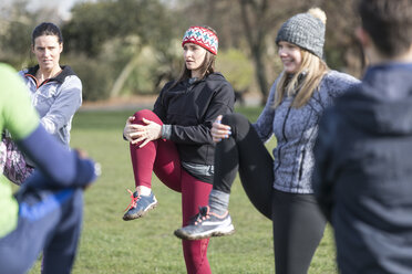 Frauen trainieren, dehnen sich im sonnigen Park - CAIF21196