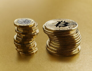 Goldene Bitcoins neben britischen Pfundmünzen gestapelt - CAIF21223