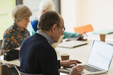 Älterer Geschäftsmann benutzt Laptop in einer Besprechung - CAIF21234