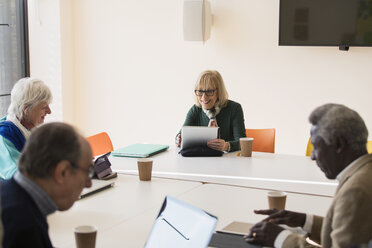 Senior businesswoman using digital tablet, leading conference room meeting - CAIF21241