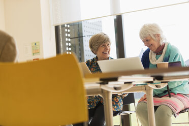 Ältere Geschäftsfrauen benutzen Laptops in einem Konferenzraum - CAIF21242