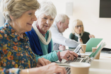 Ältere Geschäftsfrauen benutzen Laptops in einem Konferenzraum - CAIF21244