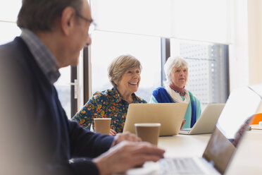 Senior businesswomen using laptops in conference room meeting - CAIF21253