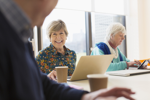 Ältere Geschäftsfrau mit Laptop in einem Konferenzraum, lizenzfreies Stockfoto