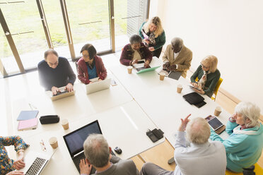 Ältere Geschäftsleute verwenden Laptops und digitale Tablets in einem Konferenzraum - CAIF21276