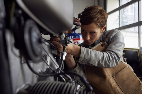 Woman working in repair workshop - RBF06424