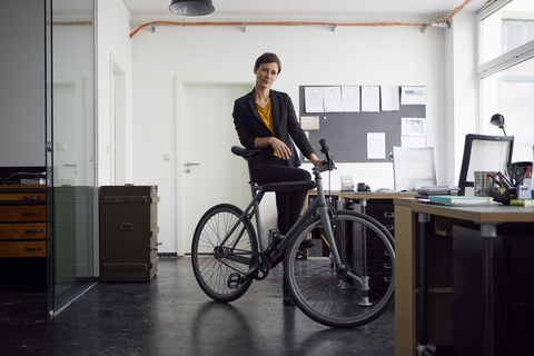 Businesswoman with bicycle in her start-up company stock photo