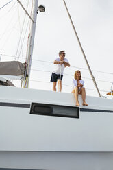 Mature couple making holidays, sailing on a catamaran - EBSF02575