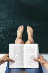 Woman sitting on sailing boat, reading a book - EBSF02593