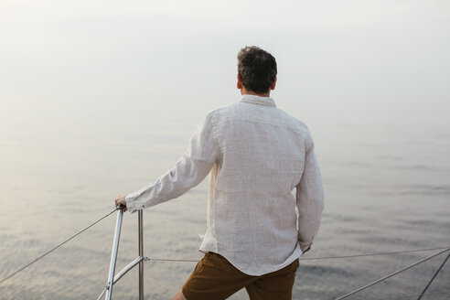 Marure man on catamaran, looking ta view - EBSF02597