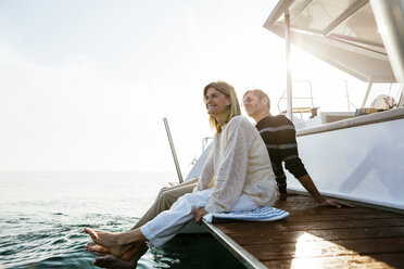 Mature couple sitting on jetty, relaxing at the sea - EBSF02644