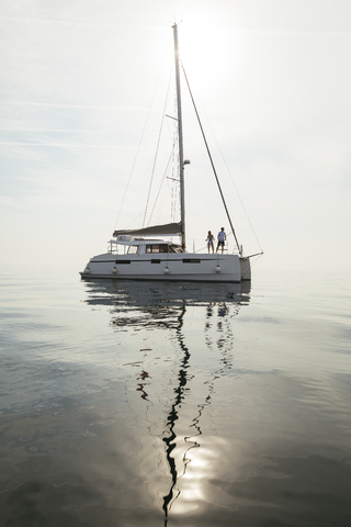 Paar auf dem Weg zu einem Segeltörn auf einem Katamaran, lizenzfreies Stockfoto