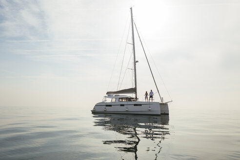 Couple setting off for a sailing trip on a catamaran - EBSF02665