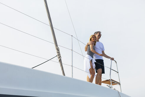 Mature couple making holidays, sailing on a catamaran - EBSF02669