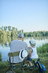 Rückenansicht von Großvater und Enkel beim gemeinsamen Angeln am Seeufer - ZEDF01475