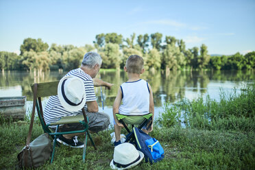 Rückansicht von Großvater und Enkel beim gemeinsamen Angeln am Seeufer - ZEDF01478