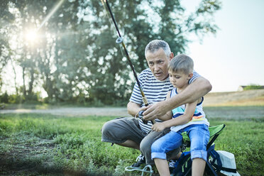 Großvater und Enkel angeln gemeinsam am Seeufer - ZEDF01482
