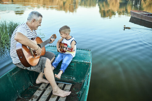 Grandfather teaching grandson playing guitar - ZEDF01499