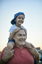 Portrait of happy little boy on shoulders of his grandfather - ZEDF01501
