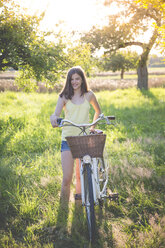 Porträt eines lächelnden Mädchens mit Fahrrad in der Natur - LVF07304