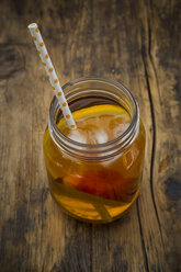 Glass of peach orange ice tea on wood - LVF07305