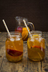 Zwei Gläser mit Pfirsich-Orangen-Eistee auf Holz - LVF07306