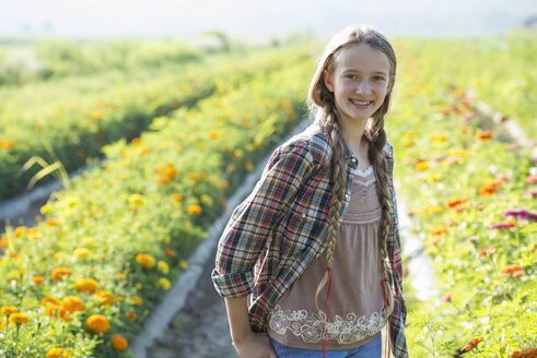 Sommer auf einem Bio-Bauernhof: Ein junges Mädchen in einem Blumenfeld. - MINF00264