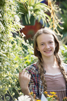 Sommer auf einem Bio-Bauernhof: Ein junges Mädchen in einer Gärtnerei voller Blumen. - MINF00265