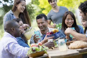 Adults and children around a table in a garden. - MINF00293