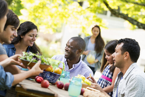 Adults and children around a table in a garden. - MINF00297