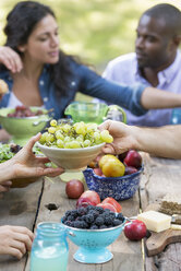 Adults and children around a table at a party in a garden. - MINF00299