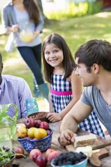 Erwachsene und Kinder um einen Tisch bei einer Party im Garten. - MINF00300