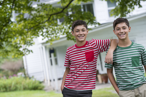 Zwei Jungen im Garten eines Bauernhauses im Sommer., lizenzfreies Stockfoto