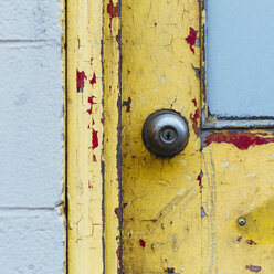 A doorway and the doorbell of a building. Flaked damaged paint. - MINF00338