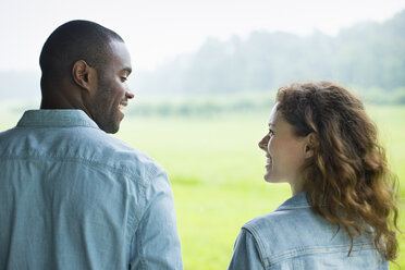 A young man and woman, a couple standing side by side. Looking at each other. - MINF00373