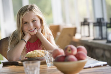 A young girl looking at a pastry pie, smiling. - MINF00396