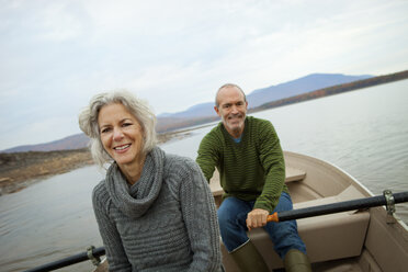 Ein Paar, Mann und Frau, sitzt an einem Herbsttag in einem Ruderboot auf dem Wasser. - MINF00424