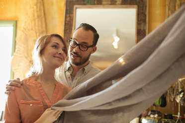 Two people, a couple running an antique store. Small business. Holding a piece of linen fabric. - MINF00426