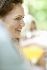 A woman sitting at a table outdoors. - MINF00432