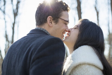 Zwei Menschen, ein Paar, ein Mann und eine Frau, die sich an einem Wintertag im Wald küssen. - MINF00436