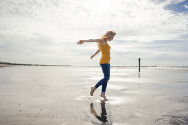 Niederlande, Zeeland, Frau tanzt am Strand - KNSF04189