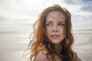Netherlands, Zeeland, portrait of redheaded woman with freckles on the beach - KNSF04191