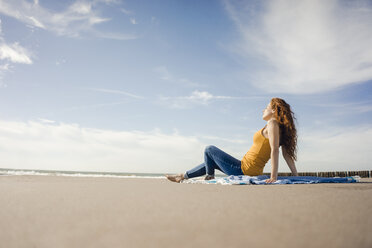 Netherlands, Zeeland, redheaded woman relaxing on the beach - KNSF04193