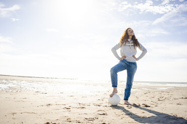 Niederlande, Zeeland, Frau mit Fußball am Strand - KNSF04200