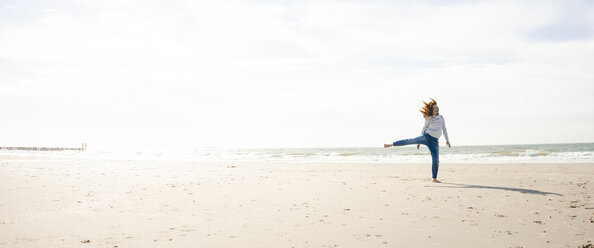 Netherlands, Zeeland, woman having fun on the beach - KNSF04201
