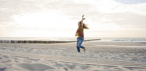 Netherlands, Zeeland, happy woman dancing on the beach - KNSF04205