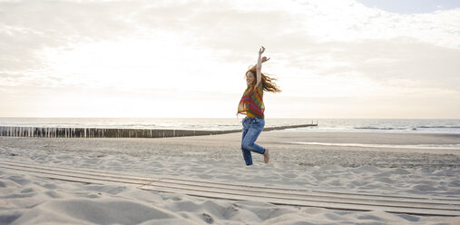 Niederlande, Zeeland, glückliche Frau tanzt am Strand - KNSF04205